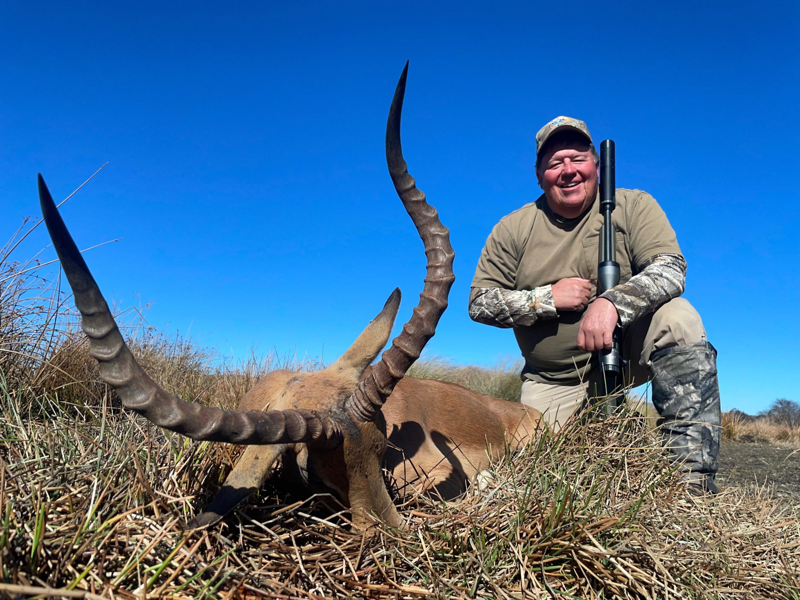 Safari hunter with trophy horns against the African sky